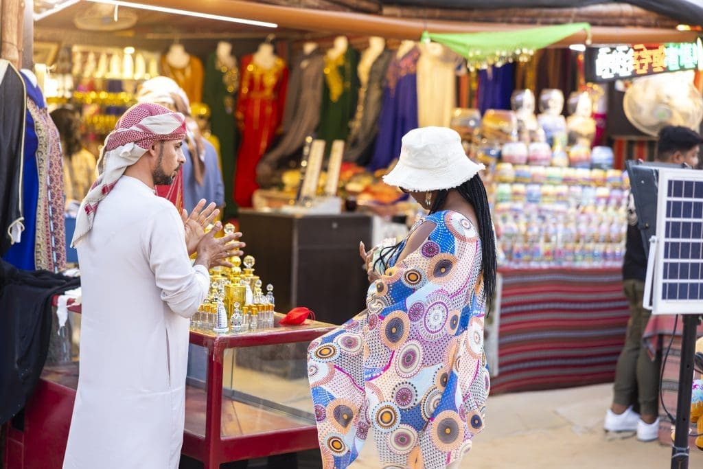Black woman and Arabic vendor in outdoor shopping stall in Dubai