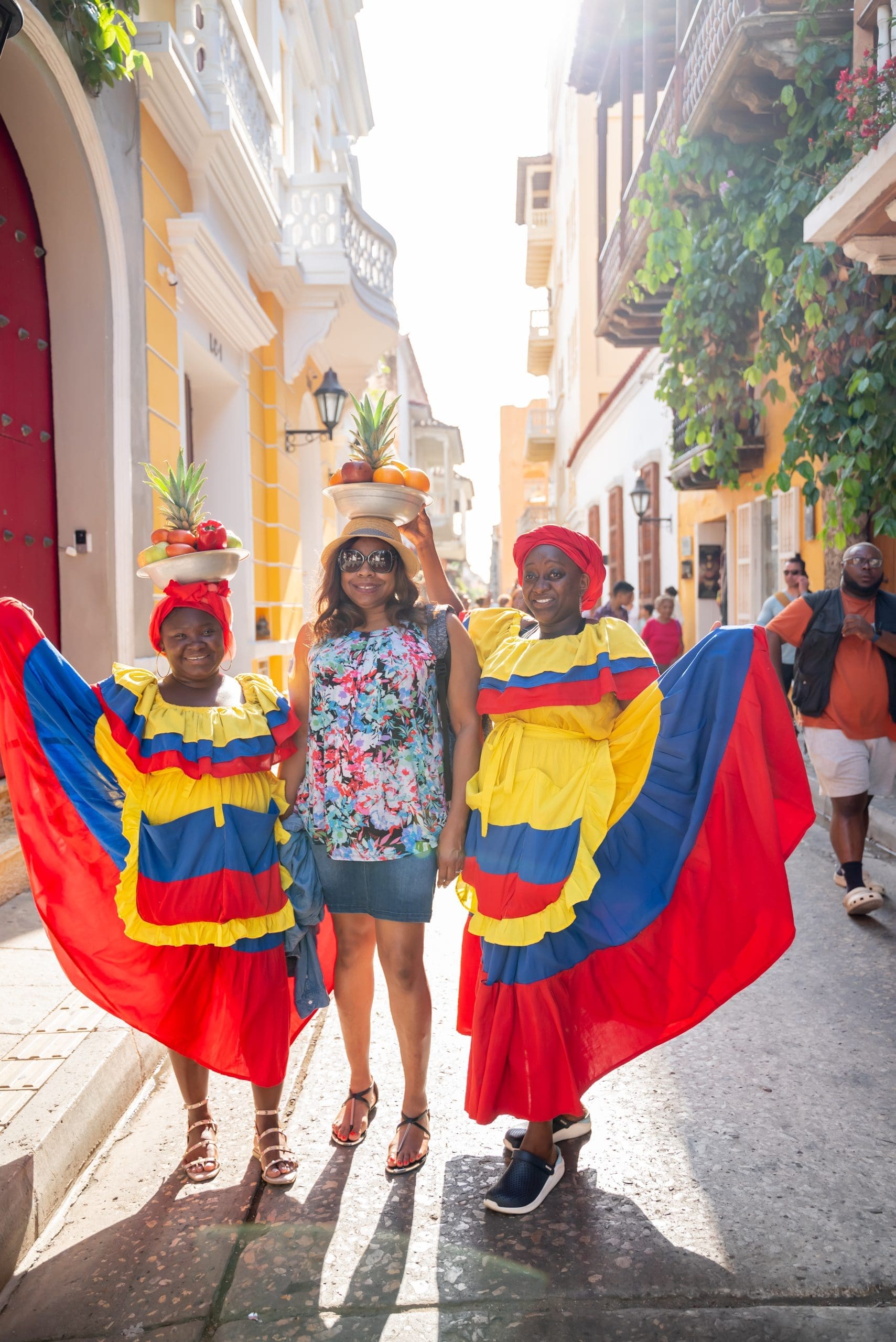 black woman with Columbian women in colorful native garb on the street in Catagena