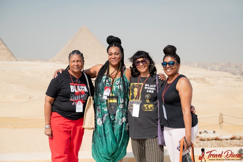 group of travel divas in front of the pyramids in Egypt smiling.