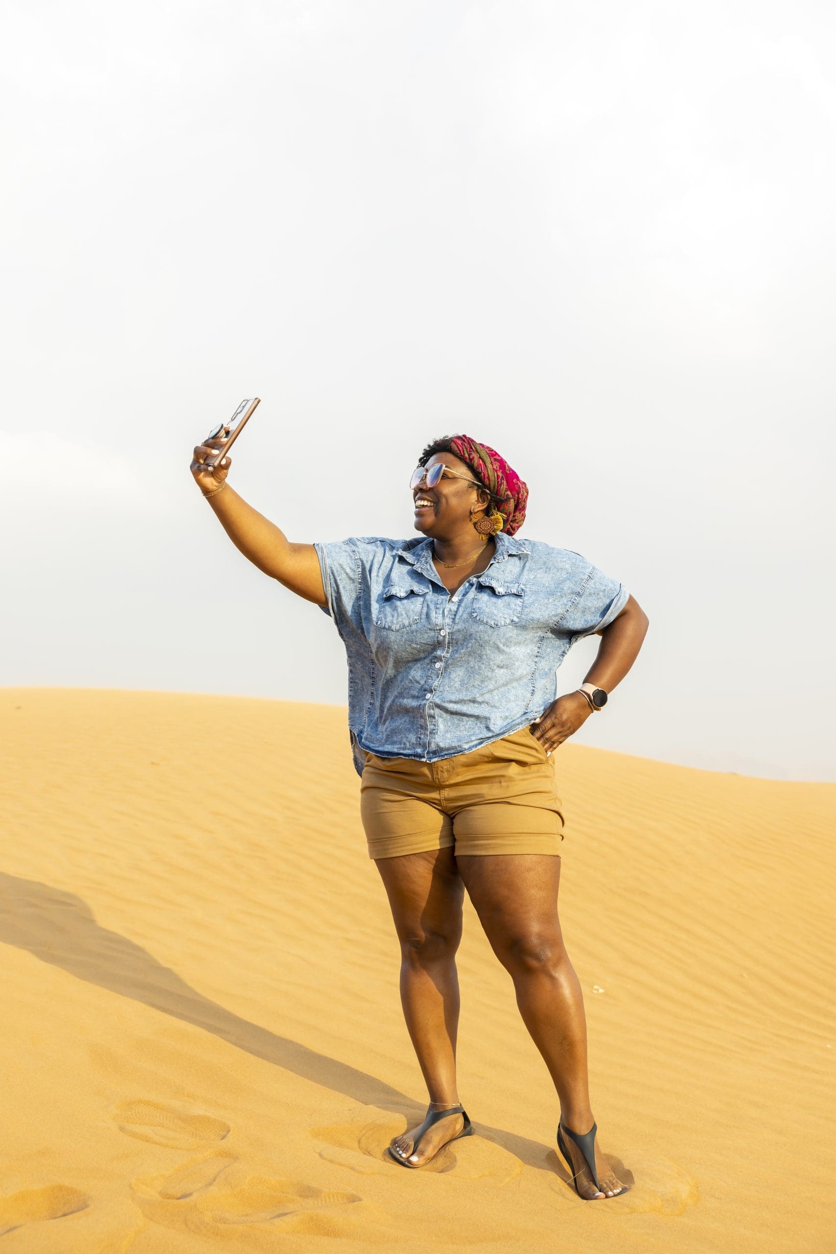 Black woman taking selfie in Dubai Desert