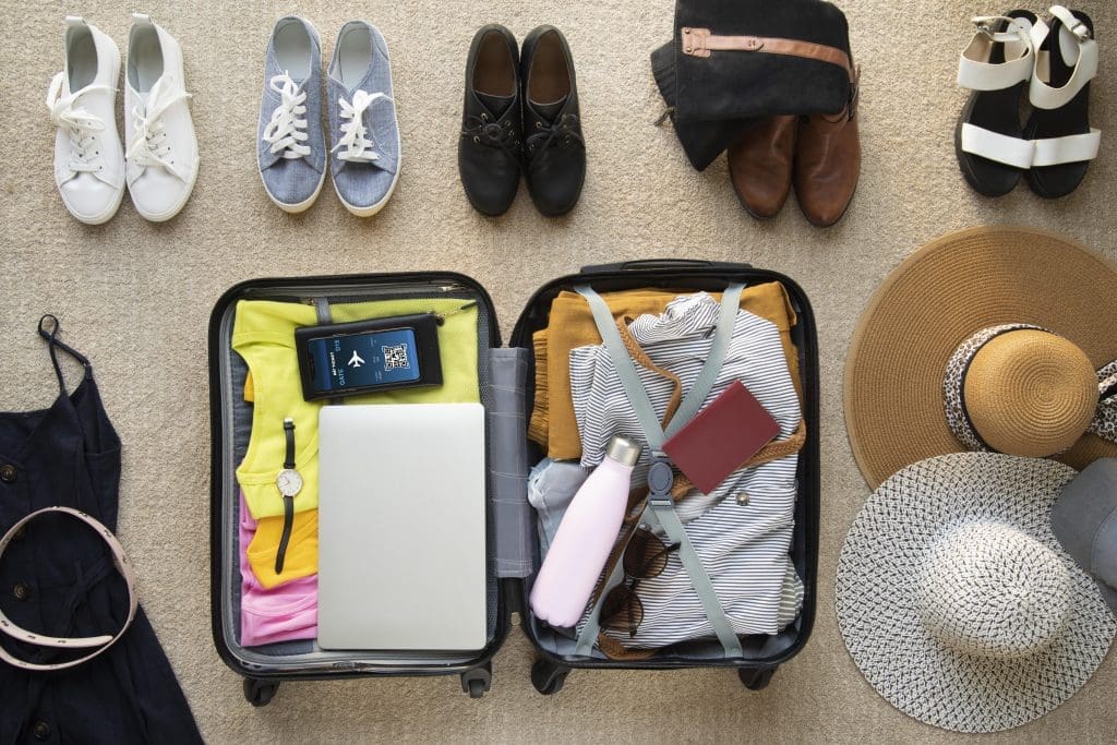 Open suitcase with clothing options and electronics