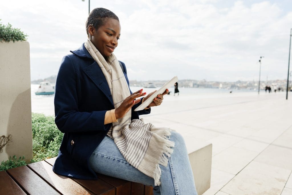 Black happy woman using a digital tablet outdoors close up